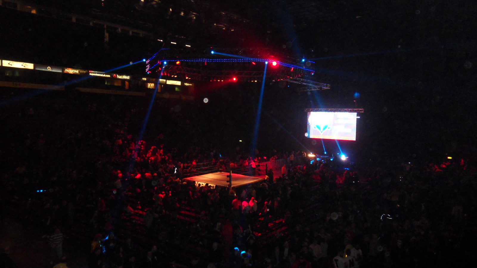 Un'arena di wrestling al buio con il ring illuminato, da uno degli eventi a cui ero presente